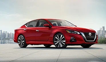 2023 Nissan Altima in red with city in background illustrating last year's 2022 model in Nissan of Florence in Florence AL
